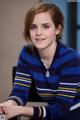 A woman in a blue and yellow striped sweater sitting on a chair.