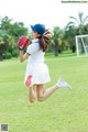 A woman in a baseball uniform is jumping in the air.