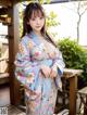 A woman in a blue kimono posing for the camera.