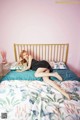 A woman laying on top of a bed in a bedroom.