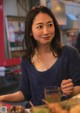 A woman sitting at a table with a glass of water.