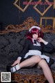 A woman in a maid outfit sitting on a couch.