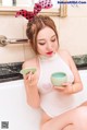 A woman sitting in a bathtub holding a cup of tea.