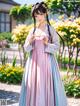 A woman in a pink and blue dress standing in a garden.