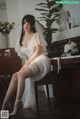 A woman in a wedding dress sitting on a piano.