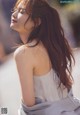 A woman with long brown hair is posing for a magazine.