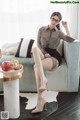 a woman sitting on top of a couch next to a bowl of fruit